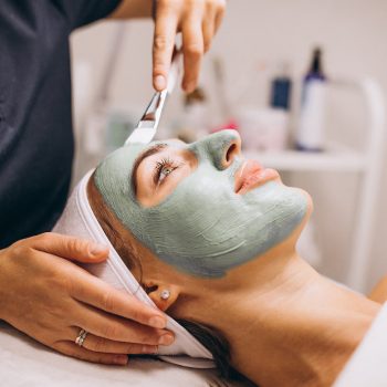 cosmetologist-applying-mask-face-client-beauty-salon (1)